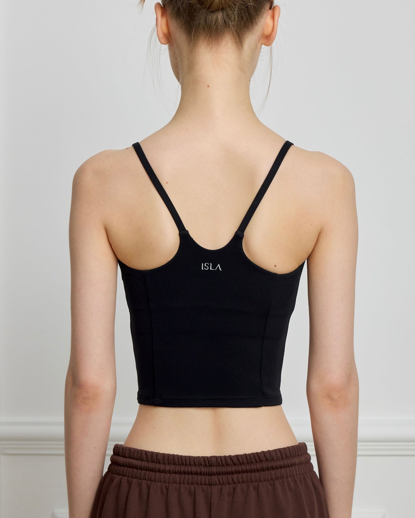 Back view of ISLAHOLA Contour Longline Bra Top in Core Black featuring slim straps and a supportive longline fit.